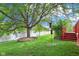 A lush backyard featuring a large tree providing shade, along with a view of the tranquil lake at 7970 Cobblesprings Dr, Avon, IN 46123
