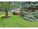 Landscaped backyard with a spacious lawn, mature trees, and a charming red deck, perfect for relaxation at 7970 Cobblesprings Dr, Avon, IN 46123