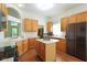 Spacious kitchen with wood cabinets, a center island, and black appliances, perfect for cooking and storage at 7970 Cobblesprings Dr, Avon, IN 46123