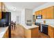 Open kitchen with wood cabinets and an island, showcasing ample counter space and modern black appliances at 7970 Cobblesprings Dr, Avon, IN 46123