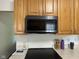 Kitchen with stainless steel microwave above flat top range and wood kitchen cabinetry at 7970 Cobblesprings Dr, Avon, IN 46123