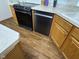 Galley style kitchen features wood-look vinyl floors, stainless steel dishwasher and electric range at 7970 Cobblesprings Dr, Avon, IN 46123