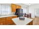 Bright kitchen featuring wooden cabinets, black appliances, and an island, ideal for meal preparation at 7970 Cobblesprings Dr, Avon, IN 46123