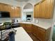 Well-lit kitchen with wood cabinets, stainless steel dishwasher, and cozy breakfast nook view at 7970 Cobblesprings Dr, Avon, IN 46123