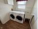 Laundry room with modern washer and dryer and sink with laminate flooring at 7970 Cobblesprings Dr, Avon, IN 46123