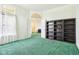 Bright living room with green carpet, large windows, and a built-in dark wood bookshelf at 7970 Cobblesprings Dr, Avon, IN 46123