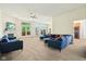 Spacious living room with a fireplace, large windows, and modern blue couches at 7970 Cobblesprings Dr, Avon, IN 46123