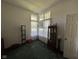 Well-lit living room with multiple windows, display cabinet, and green carpeting at 7970 Cobblesprings Dr, Avon, IN 46123