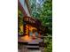 Inviting wooden deck with ambient string lights, comfortable lounge chairs, and views of the surrounding mature trees at 8209 Beech Knoll, Indianapolis, IN 46256