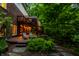 Exterior wooden deck features ambient lighting and seating, creating an inviting space to enjoy the surrounding lush greenery at 8209 Beech Knoll, Indianapolis, IN 46256