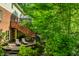 Spacious backyard deck with seating and stairs leading to a lush, green yard with mature trees and landscaping at 8209 Beech Knoll, Indianapolis, IN 46256