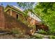 Spacious backyard with brick retaining wall, staircase and elevated deck, surrounded by mature trees and lush landscaping at 8209 Beech Knoll, Indianapolis, IN 46256