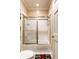 Cozy bathroom featuring a tub with glass sliding doors and decorative diamond tile accents at 8209 Beech Knoll, Indianapolis, IN 46256