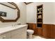 Stylish half-bath with paneled walls, decorative mirror, a floating shelf and a white vanity, for added convenience at 8209 Beech Knoll, Indianapolis, IN 46256