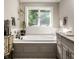 Beautiful bathroom featuring a soaking tub, a large window, and a stylish vanity at 8209 Beech Knoll, Indianapolis, IN 46256