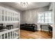Well-lit bedroom with hardwood floors, bunkbeds, a sofa, desk, and decorative chandelier at 8209 Beech Knoll, Indianapolis, IN 46256
