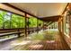 This large covered wooden deck features built-in bench seating and views of the surrounding lush, green landscape at 8209 Beech Knoll, Indianapolis, IN 46256