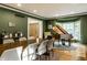 Dining room features hardwood floors, an area rug, a piano, and a wooden entry door at 8209 Beech Knoll, Indianapolis, IN 46256