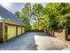 Long driveway leading to a spacious three-car garage with exterior lighting and brick accents at 8209 Beech Knoll, Indianapolis, IN 46256