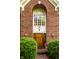 Stylish brick entryway with large windows, wooden front door, and manicured shrubs at 8209 Beech Knoll, Indianapolis, IN 46256