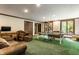 Bright, expansive game room with ping pong, ample seating and a glimpse of outdoor scenery through the windows at 8209 Beech Knoll, Indianapolis, IN 46256