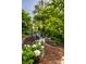 Outdoor patio area with comfortable seating, surrounded by lush greenery, and a brick-lined walkway at 8209 Beech Knoll, Indianapolis, IN 46256