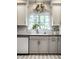 Gray cabinets complement this kitchen with granite countertop, white backsplash, and stainless fixtures at 8209 Beech Knoll, Indianapolis, IN 46256