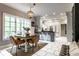 Bright kitchen featuring white cabinets, a gray island with seating, and adjacent dining area at 8209 Beech Knoll, Indianapolis, IN 46256