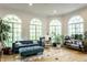 Bright living room features hardwood floors, a sofa, and large arched windows for natural light at 8209 Beech Knoll, Indianapolis, IN 46256
