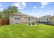 View of the backyard with a concrete patio and seating area, all surrounded by a grassy lawn at 909 E Markwood Ave, Indianapolis, IN 46227
