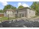 Side view of a single-story house with a stone exterior and a fenced yard at 909 E Markwood Ave, Indianapolis, IN 46227