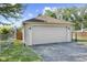 Detached garage with a white door and stone accents, complemented by a paved driveway at 909 E Markwood Ave, Indianapolis, IN 46227