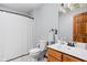 Bright bathroom featuring a single sink vanity, classic wood door, and shower with white curtain at 9159 E County Road 400 N, Brownsburg, IN 46112