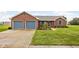 Charming brick home with a well-manicured lawn and a two-car garage and light blue shutters at 9159 E County Road 400 N, Brownsburg, IN 46112