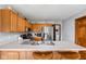 Well-appointed kitchen with stainless steel appliances and wooden cabinets and breakfast bar at 9159 E County Road 400 N, Brownsburg, IN 46112
