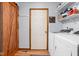 Efficient laundry room with a washer, dryer, wooden sliding door, and storage shelves at 9159 E County Road 400 N, Brownsburg, IN 46112