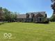 Beautifully landscaped front yard featuring a lush lawn and mature trees around the house at 916 N County Road 500 E, Avon, IN 46123