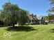 Spacious front yard with mature tree, lush green lawn, and welcoming facade of a charming home at 916 N County Road 500 E, Avon, IN 46123