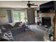Inviting living room with a gray sofa, ceiling fan, and brick fireplace with a wall-mounted TV at 916 N County Road 500 E, Avon, IN 46123