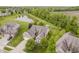 Scenic aerial view of a brick home nestled near a pond with lush greenery and landscaping at 9598 N Mariners Crst, McCordsville, IN 46055