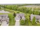 Beautiful aerial view of a brick home with a pond, manicured lawn, and mature trees at 9598 N Mariners Crst, McCordsville, IN 46055