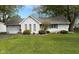 Charming one-story home with landscaped yard, small bushes, and an attached one-car garage at 1011 N 10Th St, Elwood, IN 46036