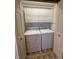 A compact laundry area featuring a stacked washer and dryer, plus functional overhead cabinetry at 1011 N 10Th St, Elwood, IN 46036