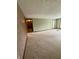 An open-concept living room with neutral carpet that leads to a hallway at 1011 N 10Th St, Elwood, IN 46036
