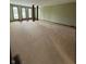 Spacious living room featuring neutral carpet, fresh paint, and natural light from large windows at 1011 N 10Th St, Elwood, IN 46036