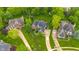 Aerial view showcasing a home, its driveway, and lush landscaping, nestled among mature trees in a neighborhood at 10390 Tremont Dr, Fishers, IN 46037