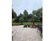 Beautiful stone patio with dining area overlooking the landscaped backyard and mature trees at 10390 Tremont Dr, Fishers, IN 46037