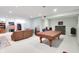 Basement recreation area features a partially covered pool table, seating area, and shelving at 10390 Tremont Dr, Fishers, IN 46037