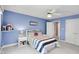 Cozy bedroom with blue walls, ceiling fan, and a comfortable bed with striped bedding at 10390 Tremont Dr, Fishers, IN 46037