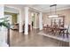 Open-concept dining area with hardwood floors, decorative columns, and views to the living room at 10390 Tremont Dr, Fishers, IN 46037
